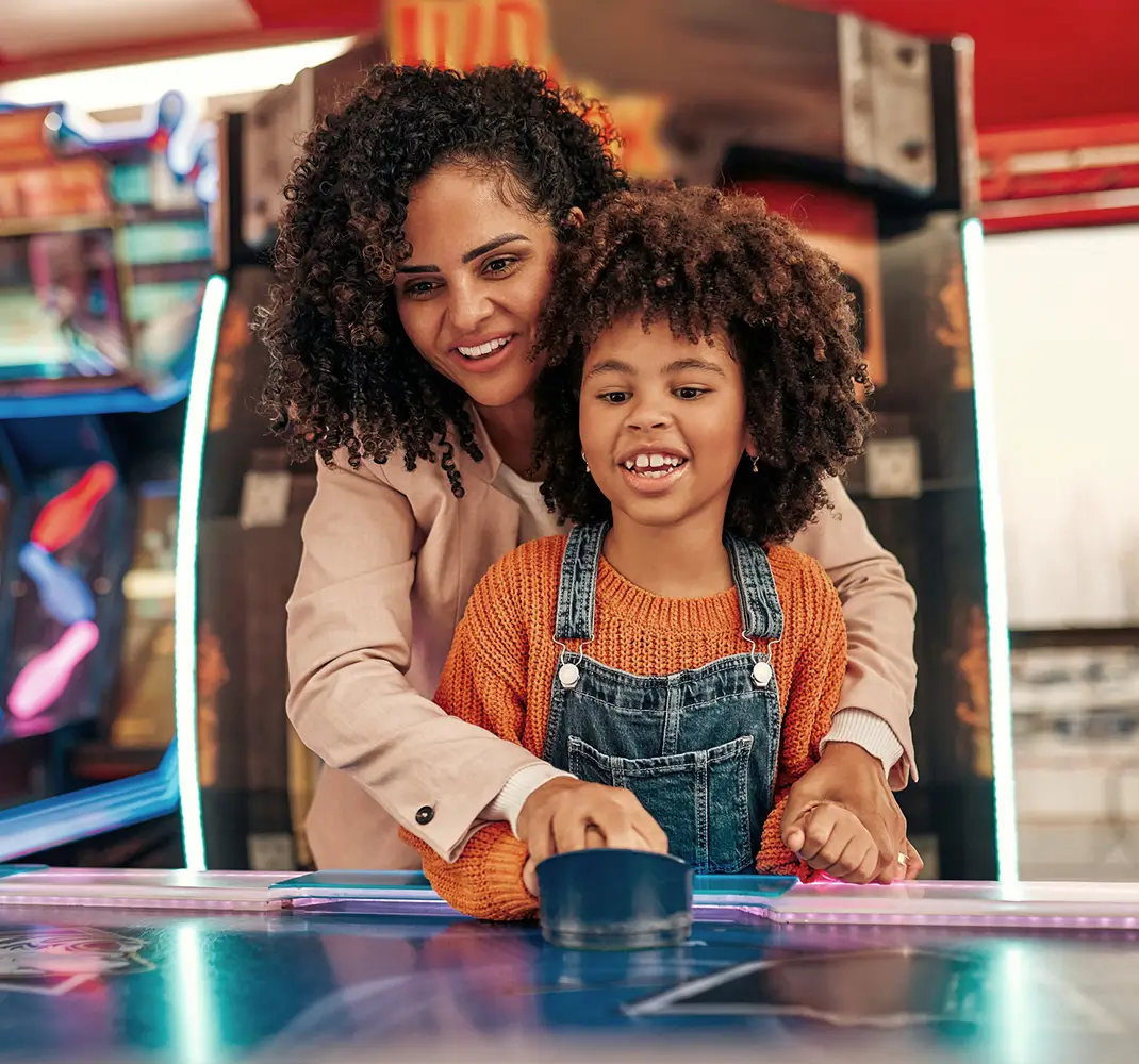 mom and daughter playing air hockey